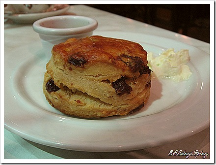 Raisin and Date Scone with Strawberry Jam and Whipped Cream - Side View Raisin and Date Scone with Strawberry Jam and Whipped Cream - Side View
